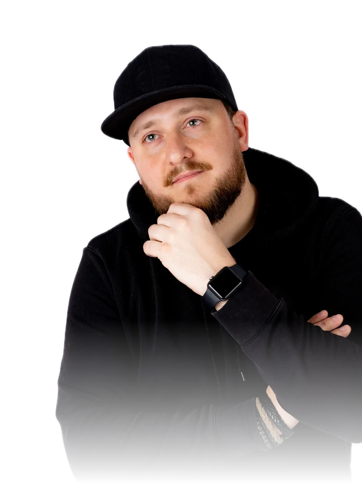 DJ Rene Amplo in a black hooded top and cap, one hand resting on his chin